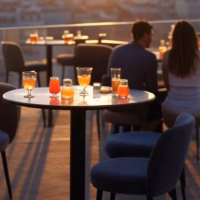 Restaurantes em Lisboa para encontros sugar dating discretos e sofisticados Elegant rooftop bar in Lisbon with panoramic sunset city views, sophisticated cocktails on table, mo