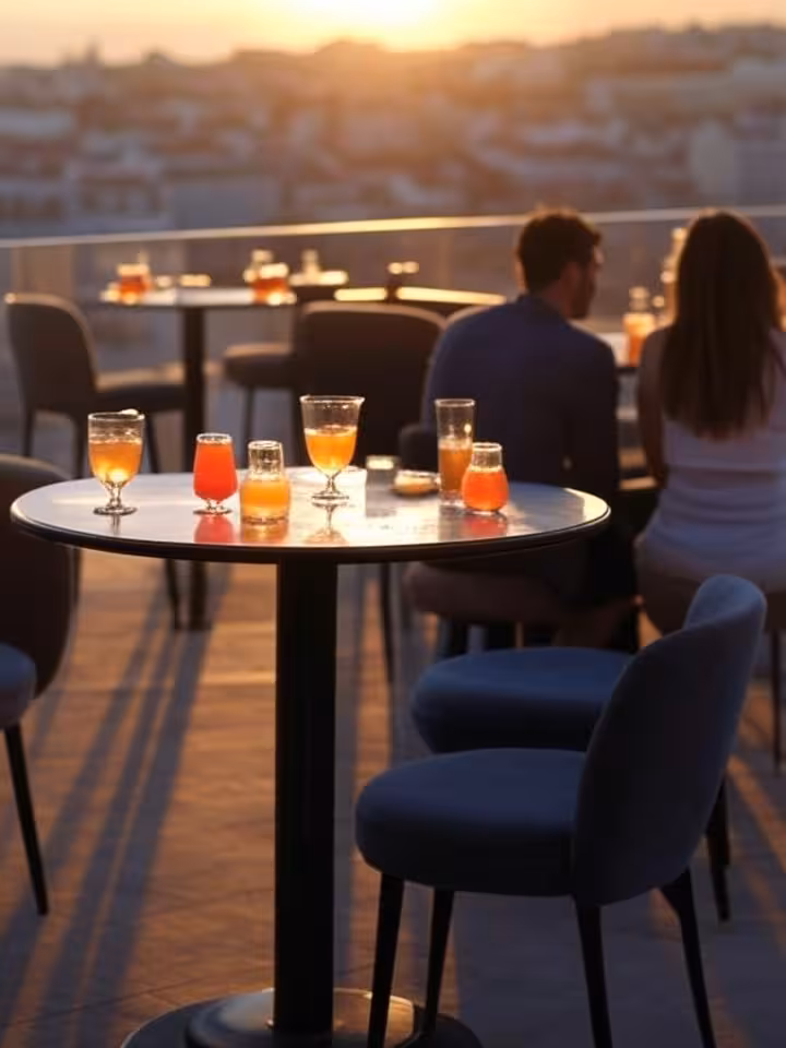 Elegant rooftop bar in Lisbon with panoramic sunset city views, sophisticated cocktails on table, mo